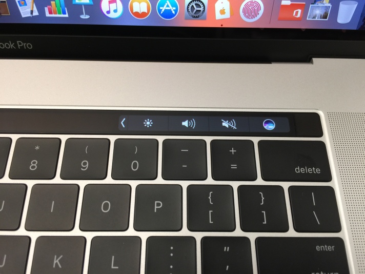 Closeup of right side of the Touch Bar showing Siri, Mute, Volume, Screen Brightness and More buttons.